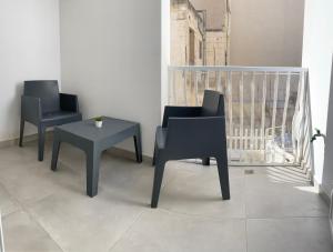 three chairs and a table in a room at Seaside Apartment in Gzira in Il-Gżira