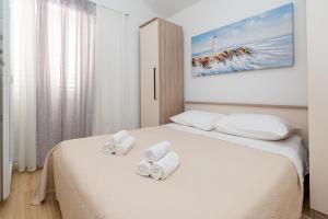 ein Schlafzimmer mit zwei gewalzten Handtüchern auf einem Bett in der Unterkunft Seaside holiday house Preko, Ugljan - 18077 in Preko