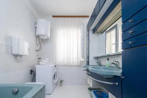 ein Bad mit 2 Waschbecken, einem WC und einem Fenster in der Unterkunft Seaside holiday house Preko, Ugljan - 18077 in Preko