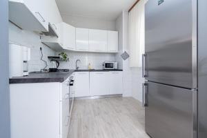 eine Küche mit weißen Schränken und einem Kühlschrank aus Edelstahl in der Unterkunft Seaside holiday house Preko, Ugljan - 18077 in Preko