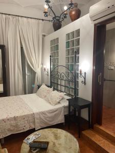 Cette chambre comprend 2 lits et une table. dans l'établissement CASA PERIN - HOSTAL RURAL, à Villafranca de los Barros