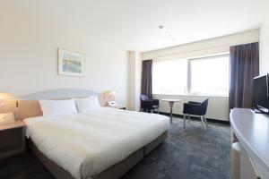 a hotel room with a bed and a table and chairs at Kawagoe Prince Hotel in Kawagoe