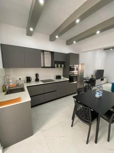 a large kitchen with a black table and chairs at Seaside Apartment in Gzira in Il-Gżira