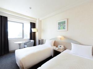 Postel nebo postele na pokoji v ubytování Kawagoe Prince Hotel