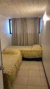 um quarto com 2 camas e uma janela em Céntrico y amoblado en Arica em Arica
