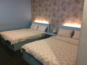 dwa łóżka siedzące obok siebie w pokoju w obiekcie Kozi Hotel - Bukit Indah w mieście Johor Bahru