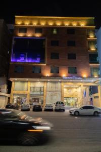 a building with cars parked in front of it at Carawan Hotel Jeddah in Jeddah