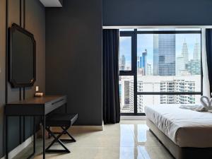 a bedroom with a bed and a desk and a window at Axon Residences Bukit Bintang in Kuala Lumpur