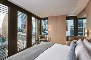 1 dormitorio con 1 cama grande y ventanas grandes en Pan Pacific London, en Londres
