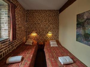 ein kleines Zimmer mit 2 Betten in einer Ziegelwand in der Unterkunft Traditional Apartment in Mesch with Terrace in Withuis
