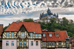 a group of houses with a castle in the background at Einzigartig - Schlossblick - Maisonette - Smart TV in Wernigerode +11 photos
