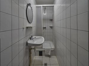 a white bathroom with a sink and a mirror at Lovely Apartment in Mesch with Parking in Mesch