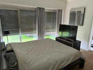 a bedroom with a bed and a flat screen tv at Vakantie appartement Limburg in Maaseik