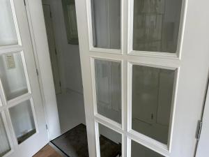 a white cabinet with glass doors in a room at Vakantie appartement Limburg in Maaseik