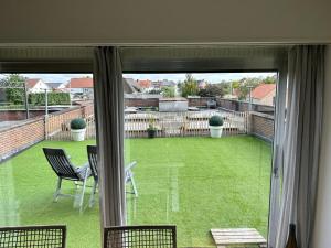 una ventana con vistas a un patio con mesa y sillas en Vakantie appartement Limburg, en Maaseik