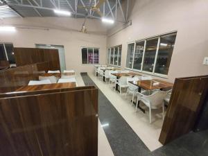une salle à manger avec des tables en bois et des chaises blanches dans l'établissement FOUR SEASONS RESORTS, à Pune