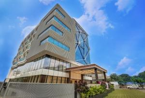 a tall building with a glass facade at Regenta Central Javaji Mysore in Mysore