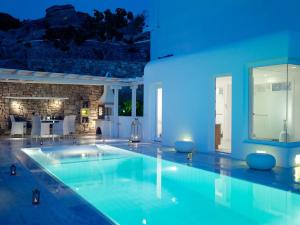 a swimming pool in a house with blue lighting at Mykonos Grand Hotel & Resort in Agios Ioannis Mykonos