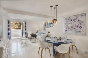 a dining room and living room with a table and chairs at Mykonos Grand Hotel & Resort in Agios Ioannis Mykonos