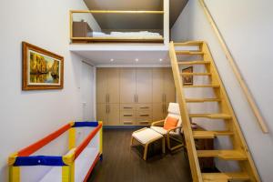 Habitación con litera y escalera en Chrysoprase Apartment, en Budapest