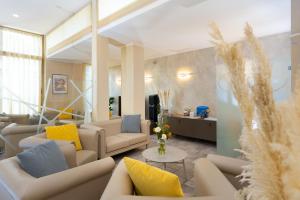 Hotel Nuova Sabrina في مارينا دي بيتراسانتا: غرفة معيشة مع كنب ووسائد صفراء وزرقاء
