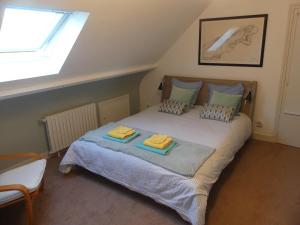 una camera da letto con un letto e due asciugamani di Le clos fleuri - Chambres d'hôtes a Onzain