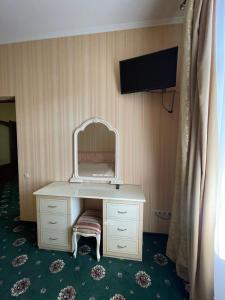 um quarto com um toucador com um espelho e uma televisão em Prestige em Lviv