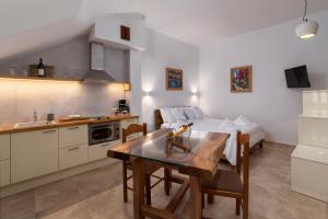 a kitchen and living room with a table and a bed at Andros 4 All Seasons Villas & Suites in Andros