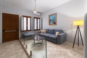 a living room with a blue couch and a glass table at Andros 4 All Seasons Villas & Suites in Andros