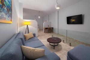 a living room with a blue couch and a table at Andros 4 All Seasons Villas & Suites in Andros