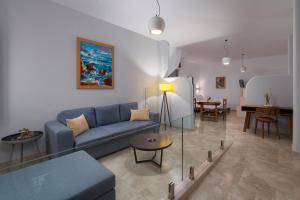 a living room with a blue couch and a table at Andros 4 All Seasons Villas & Suites in Andros