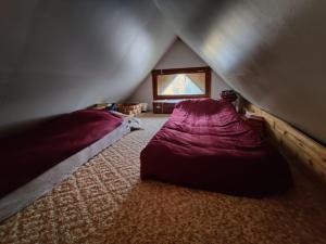 a attic bedroom with two beds and a window at Villa Jupperi Espoossa in Espoo