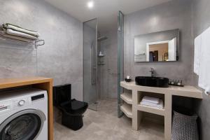 a bathroom with a sink and a washing machine at Andros 4 All Seasons Villas & Suites in Andros