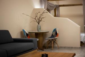a living room with a table and two chairs at Andros 4 All Seasons Villas & Suites in Andros