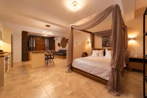 a bedroom with a canopy bed and a kitchen at Andros 4 All Seasons Villas & Suites in Andros