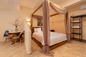 a bedroom with a canopy bed and a table at Andros 4 All Seasons Villas & Suites in Andros
