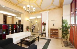 a living room with a white couch and a table at Hotel Ferney République in Paris