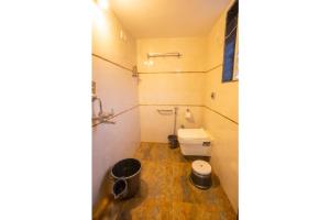 a bathroom with a toilet and a bucket at SAI 4BHK VILLA ALIBAUG in Alibaug +3 photos