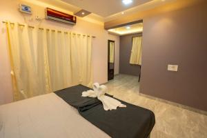 a bedroom with a bed with a white bow on it at SAI 4BHK VILLA ALIBAUG in Alibaug