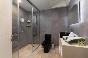 y baño con ducha y aseo. en Andros 4 All Seasons Villas & Suites, en Ándros