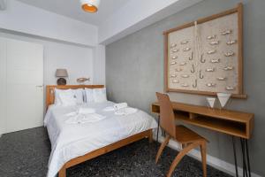 a bedroom with a bed with a desk and a bed sidx sidx sidx at Andros 4 All Seasons Villas & Suites in Andros