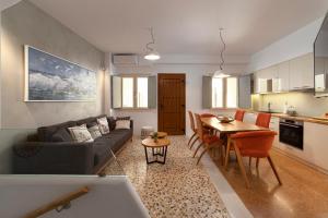 a living room and kitchen with a couch and a table at Andros 4 All Seasons Villas & Suites in Andros