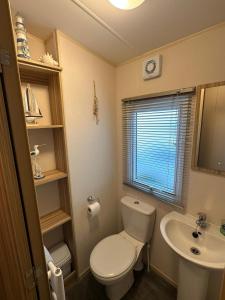 a small bathroom with a toilet and a sink at Beach life in Lossiemouth