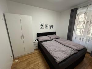 ein Schlafzimmer mit einem großen Bett und einem großen Fenster in der Unterkunft Paky Appartements 00322 in Bruck an der Leitha