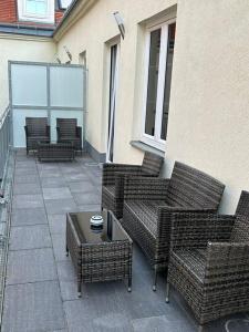 un patio con sillas de mimbre y mesa de centro en Paky Appartements 00322 en Bruck an der Leitha