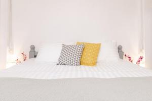ein weißes Bett mit vier Kissen darauf in der Unterkunft Garden Home 3 in Haad Yao