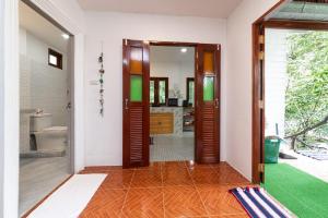 um corredor com uma porta que leva a uma casa de banho em Garden Home 3 em Haad Yao