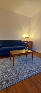 Sala de estar con sofá azul y mesa de centro en Les Friends Paisible - 1 Ch - 5 Personnes, en La Madeleine