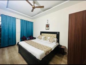 Zirakpur的住宿－Hotel Sunkriti Resort，一间卧室配有一张带蓝色窗帘的大床