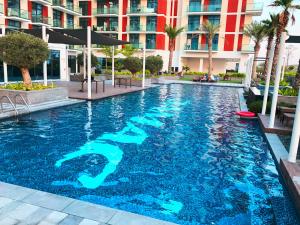 una piscina en un hotel con agua azul en Lovely one bedroom apartment with world class hotel amenities, en Dubái